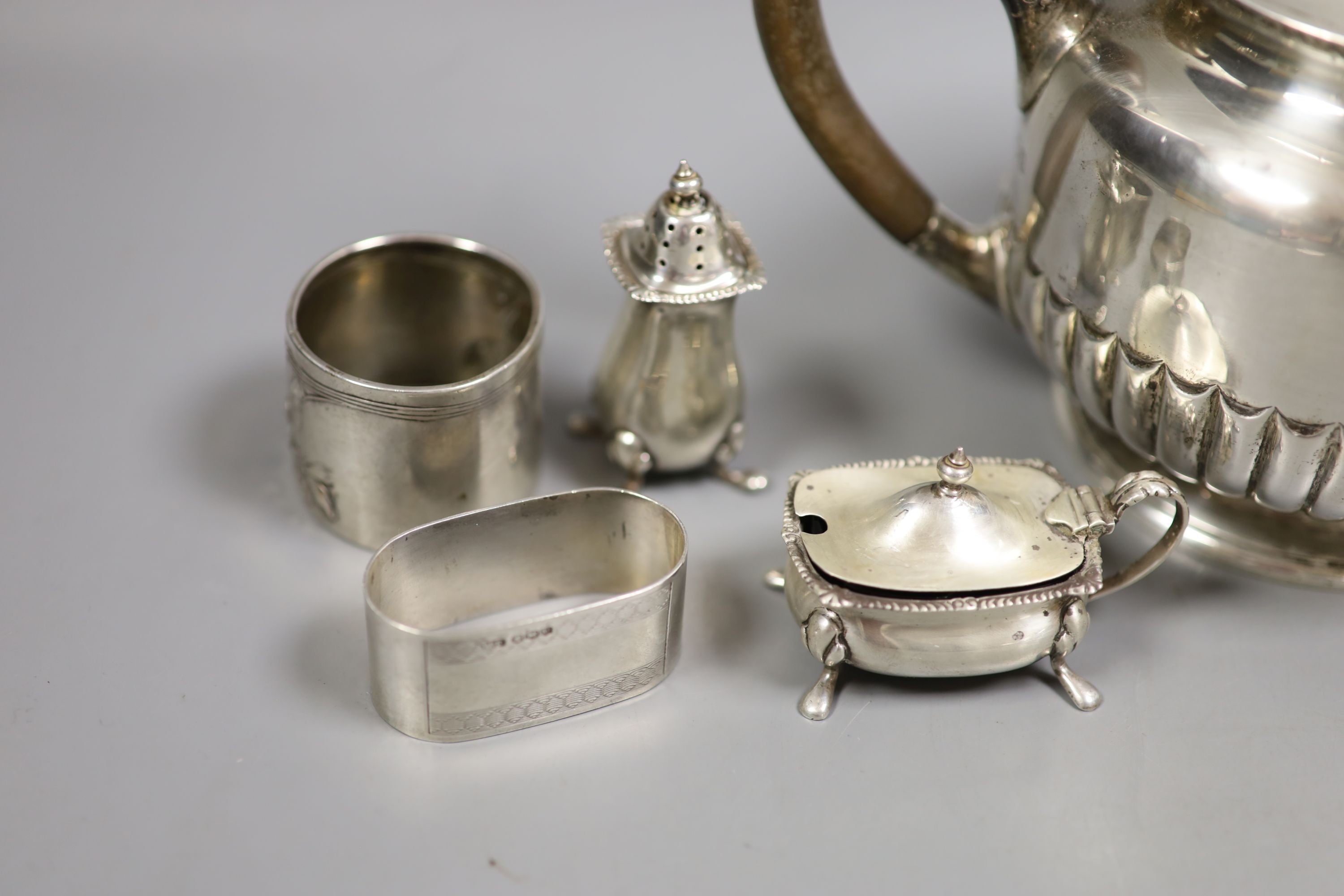 A late Victorian silver teapot, of circular half-fluted pedestal form, London 1899, Edward Barnard & Sons Ltd and a small collection of condiments